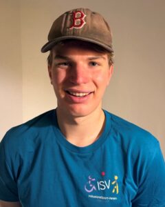 Ein junger Mann mit Baseballkappe lächelt in die Kamera und trägt ein türkisfarbenes ISV T-Shirt.