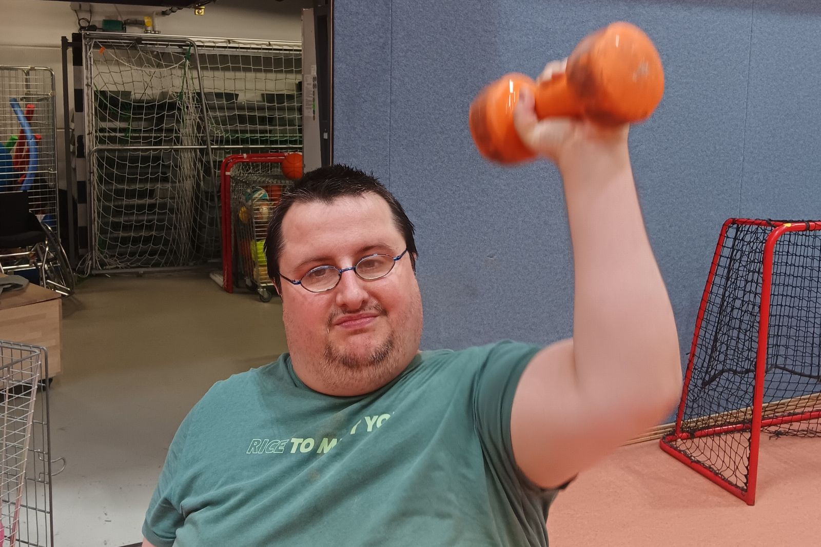 Person hebt eine Kurzhantel während einer Trainingsübung in der Halle.