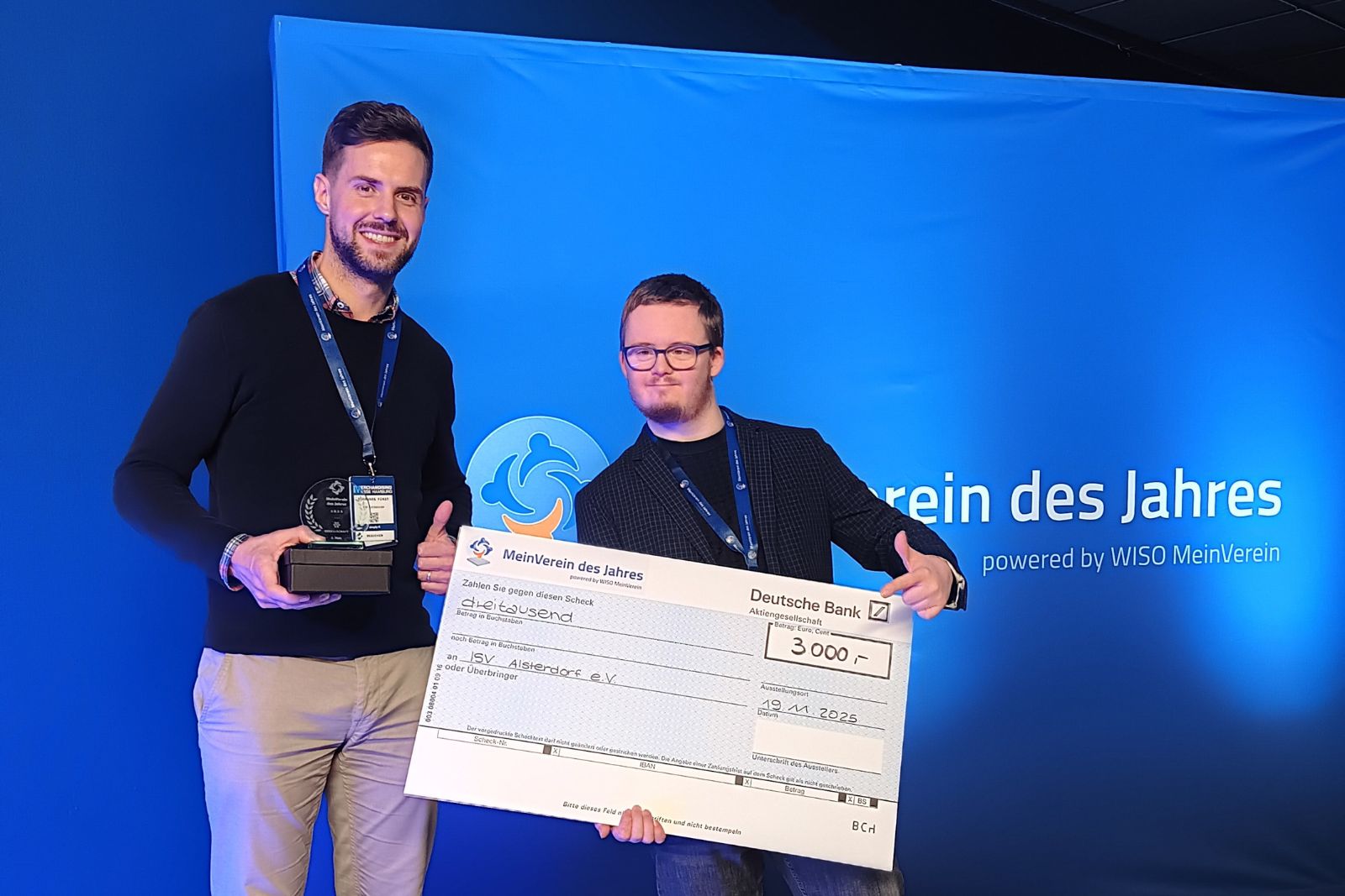 Zwei Personen halten einen symbolischen Scheck über 3.000 Euro.