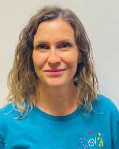 Portrait einer Trainerin des ISV Alsterdorf mit offenem Lächeln vor hellem Hintergrund.